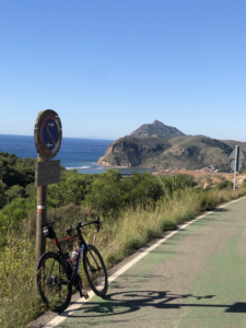 Road cyclists overlooking Portmán Bay on the Murcia Region coastline