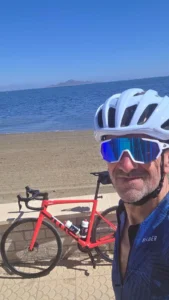 Returning OriMar Bikes customer Mick cycling with a red BMC beside the Mar Menor