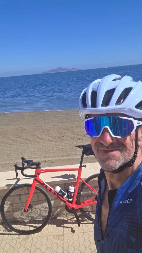 Returning OriMar Bikes customer Mick cycling with a red BMC beside the Mar Menor
